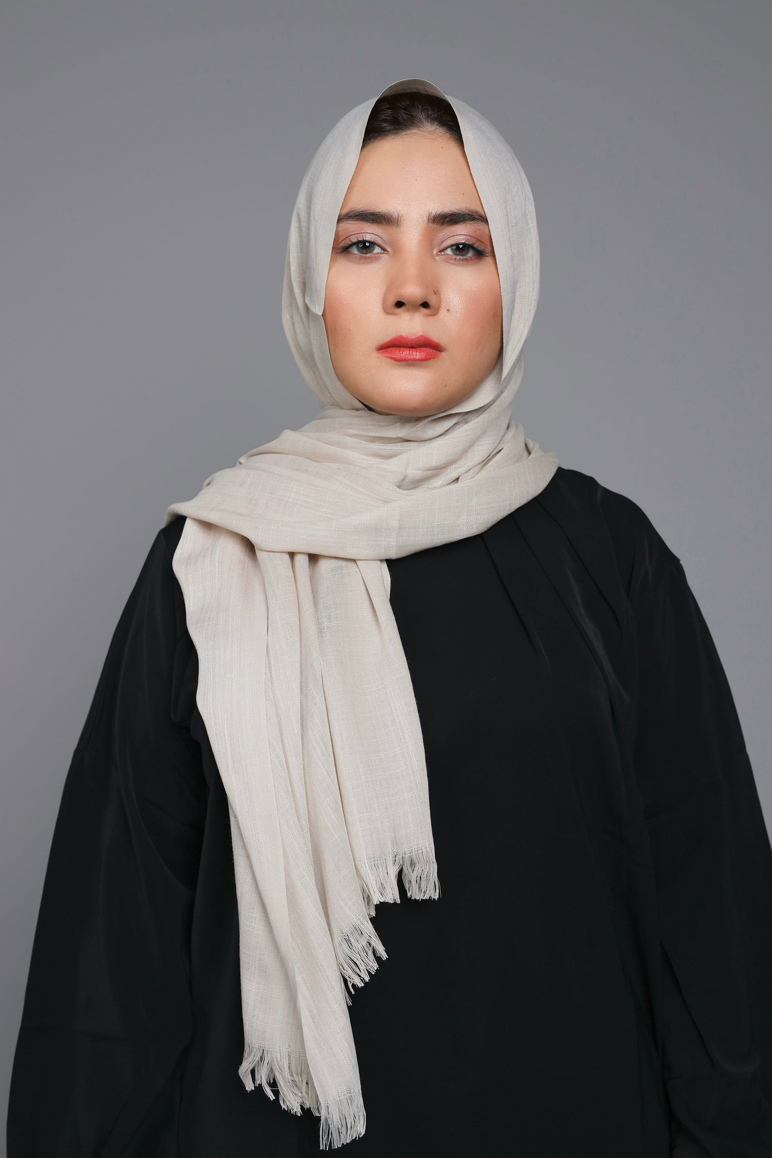 A women wearing Turkish Hijab, viscose fabric, in honey glaze colour, with white top looking her straight