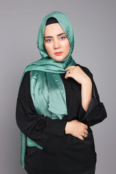 Chiffon Hijab in peridot. A woman styling it over a black top.