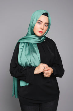 Metallic Chiffon Hijab in Peridot. Stylish Girl wearing it over black top.