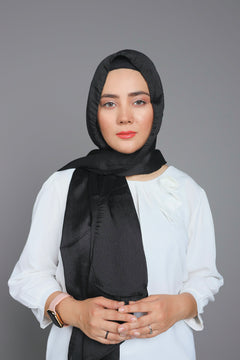 Metallic Chiffon Hijab in Black Diamond color. A woman wearing it over white top.