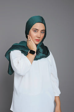 emerald green chiffon hijab. woman wearing it over white top.