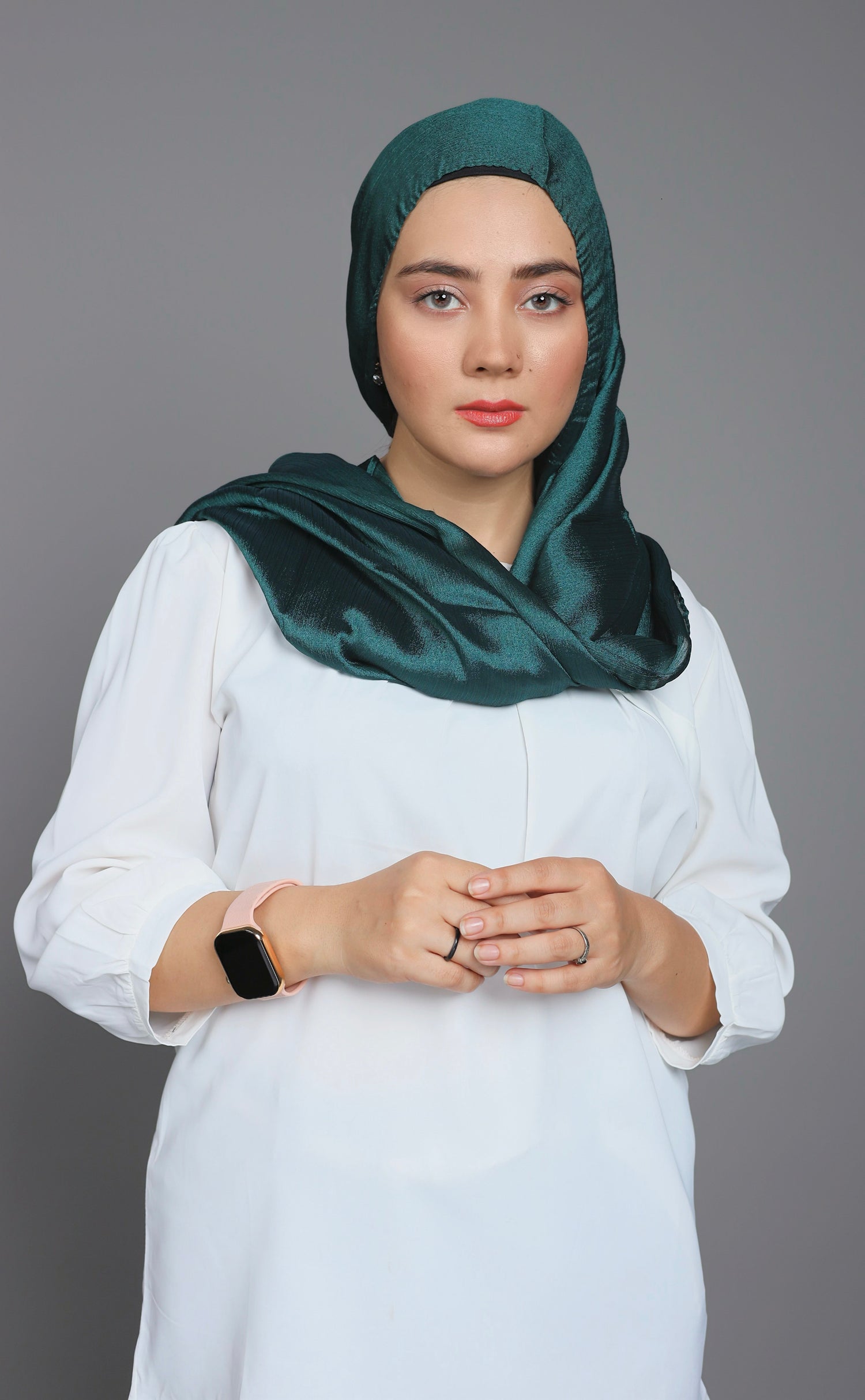 Metallic Chiffon Hijab in emerald green. Stylish Girl draping it over white top.