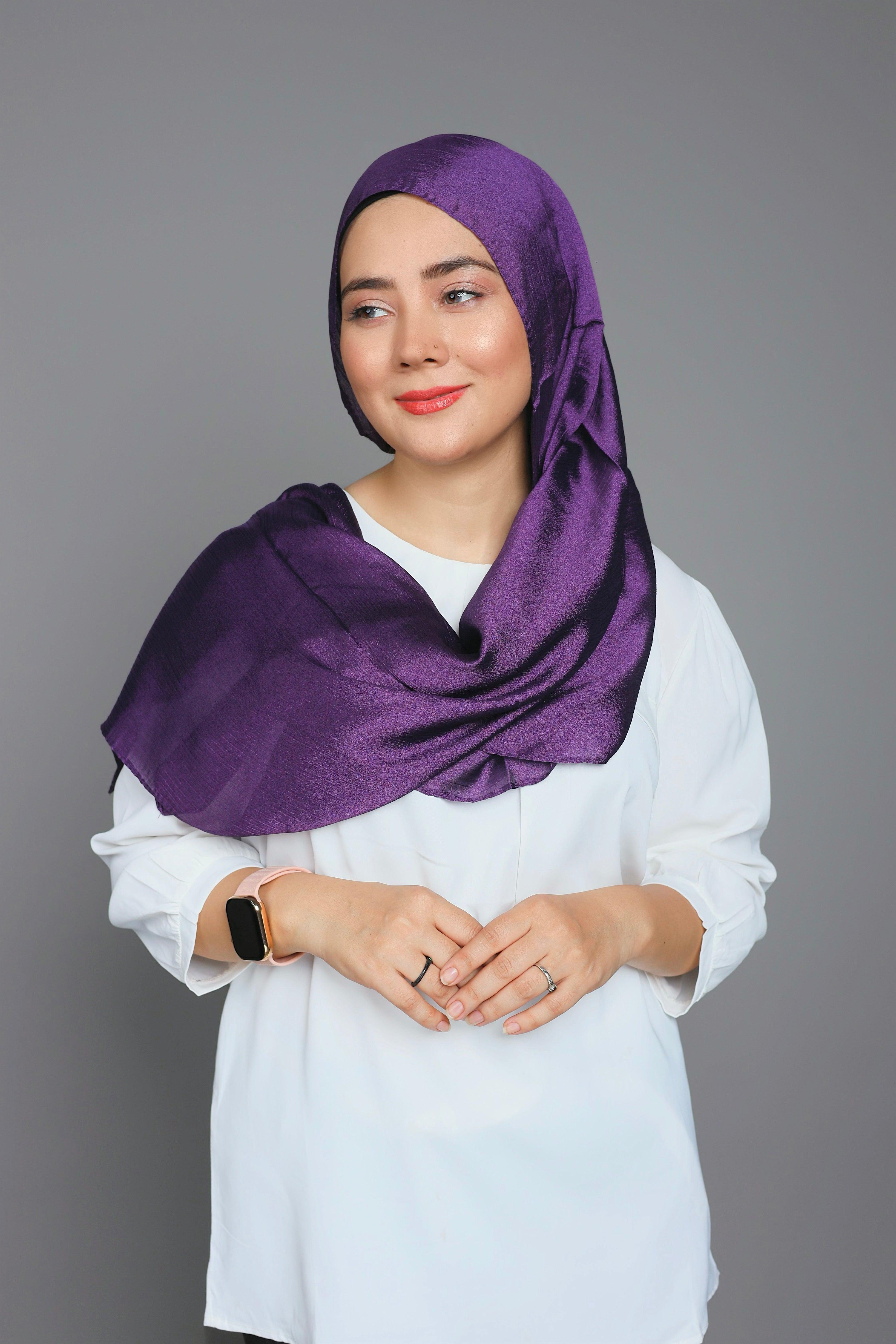 Metallic Chiffon Hijab in Dark Purple. Woman wearing it over classic white top.
