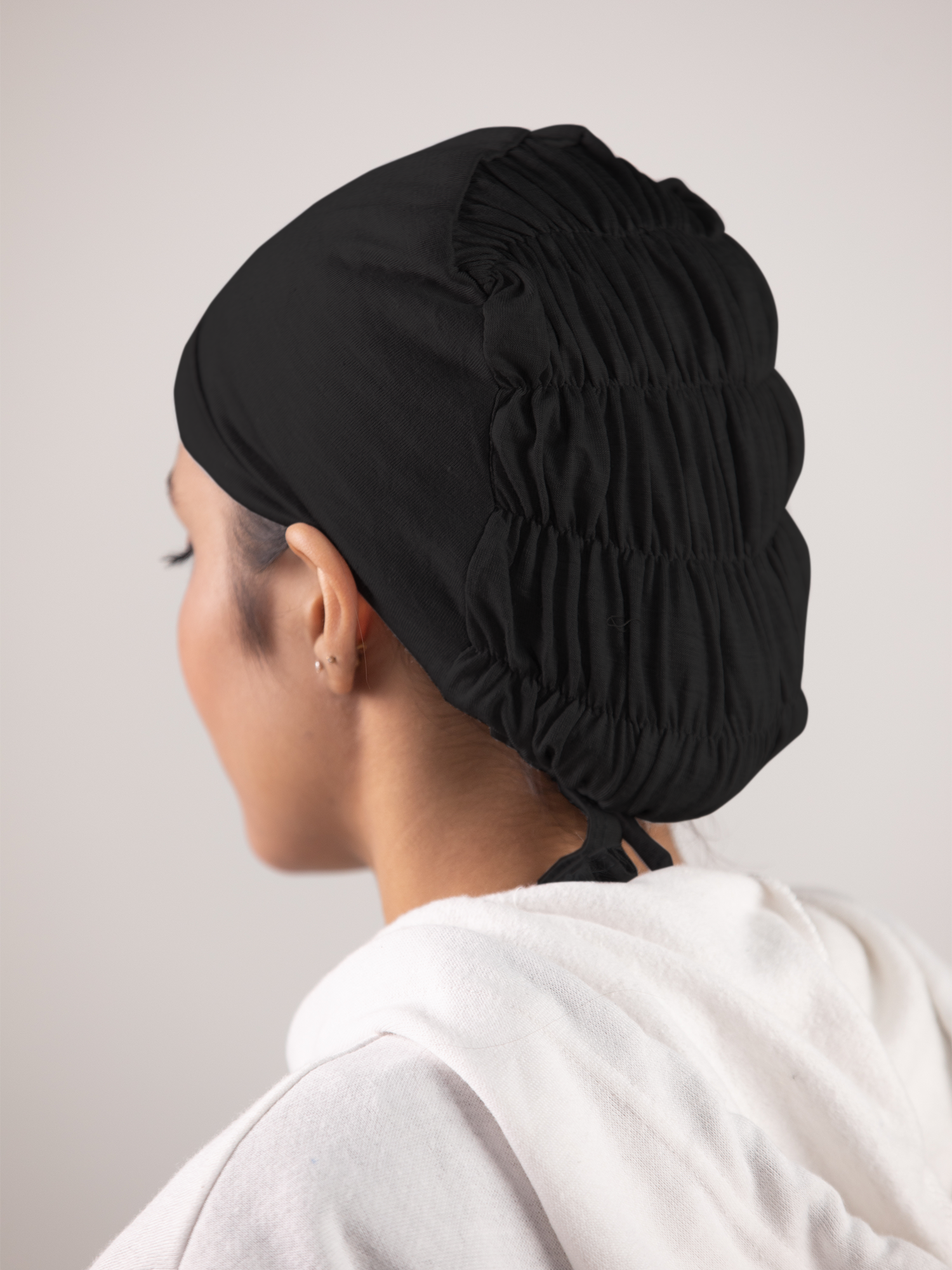 Back view of Girl wearing Ruched Hijab Cap in Black. Soft jersey fabric.