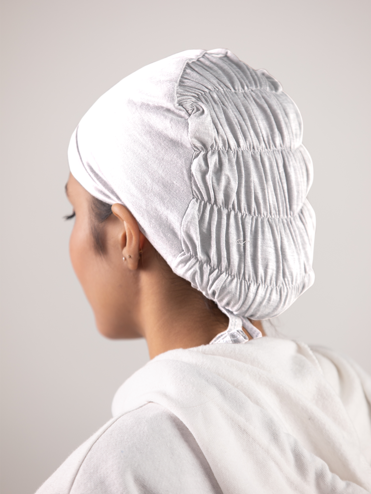 Girl wearing White Ruched Hijab Cap. Breathable fabric and ruched details.