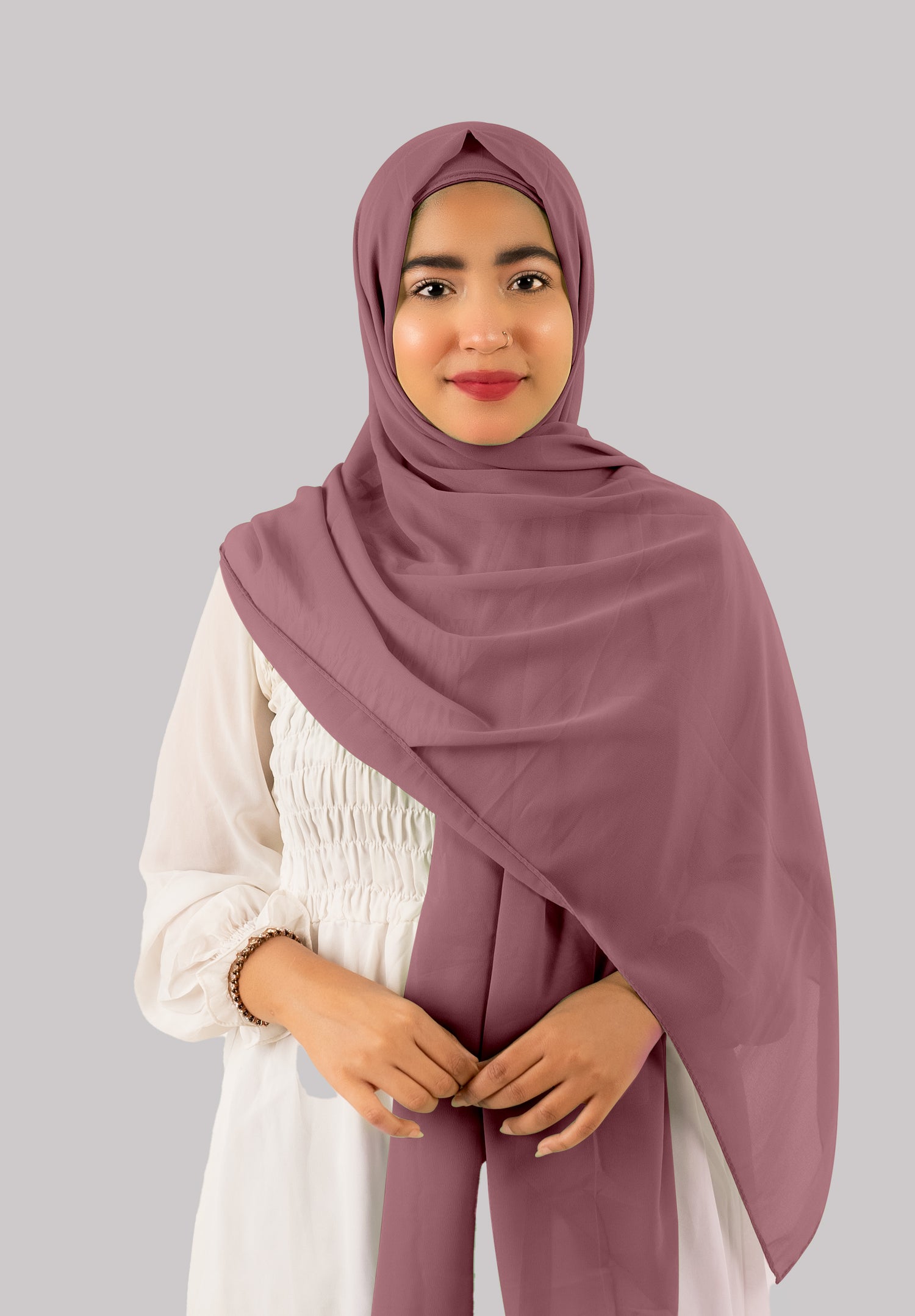 A woman wears a mauve georgette instant hijab with cap, looking her front.