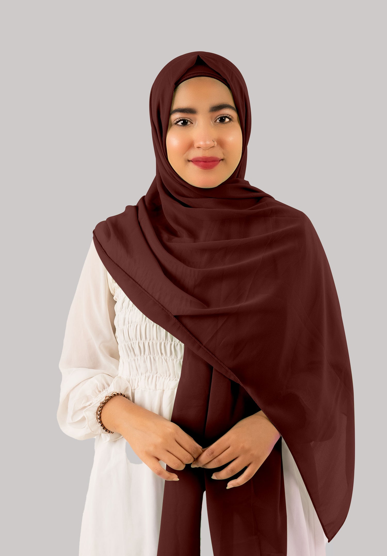 A woman wears a Nutella instant hijab with cap, featuring soft and lightweight georgette fabric. The hijab drapes beautifully, offering premium quality, and versatile styling.