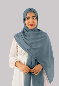 A yale blue instant hijab with cap drapes effortlessly on a woman, made from fine lightweight georgette fabric. This hijab offers sophistication, elegance, and versatile styling for modern looks.