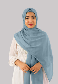 A sapphire color instant hijab with cap adorns a woman with an elegant, lightweight drape, looking her front. Made from premium georgette fabric, this hijab exudes versatility, grace, and high-end sophistication.