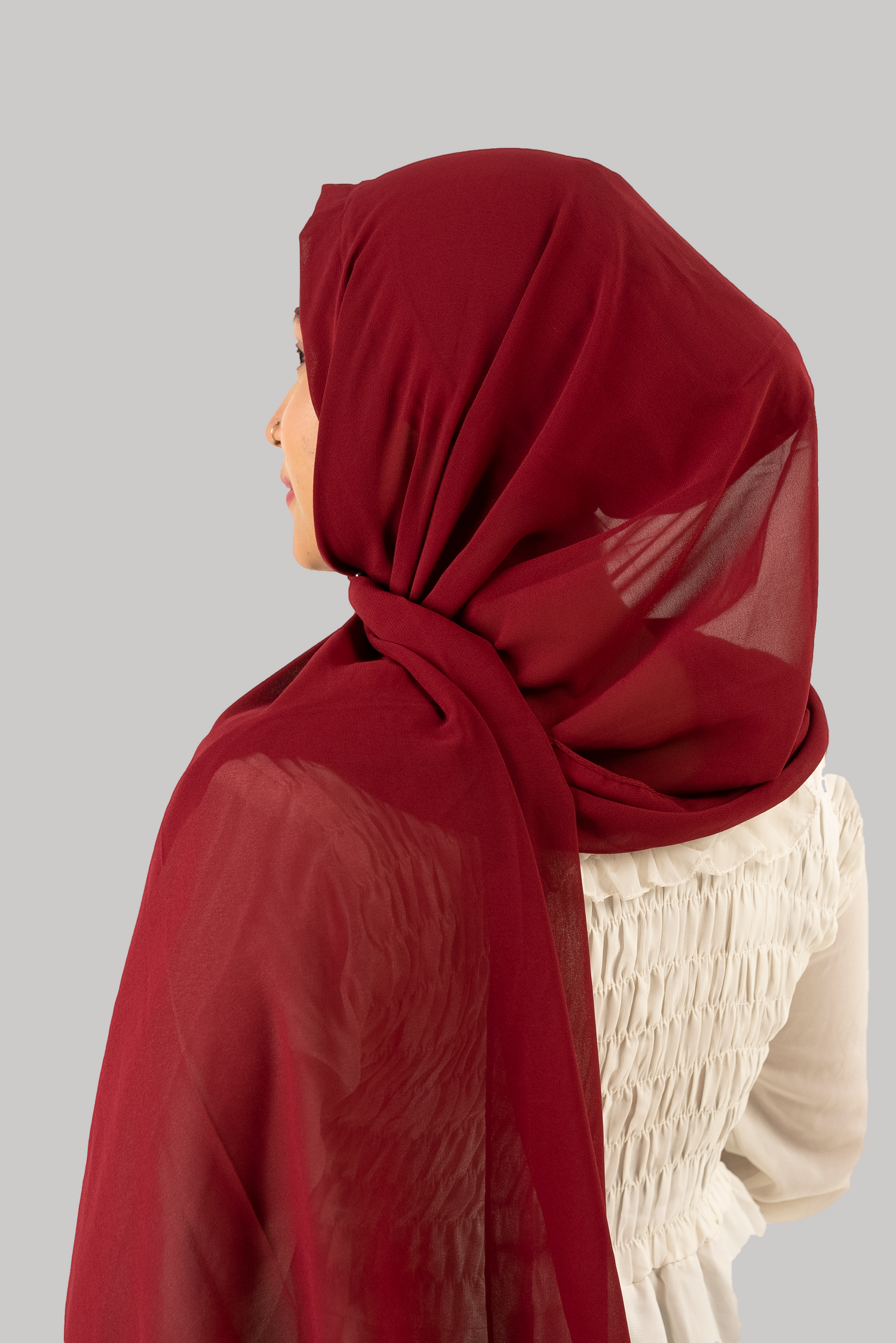 a women wearing instant hijab with cap in maroon color georgette materialback side