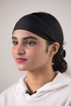 Girl wearing a Hijab Band on her head in black color looking her right.