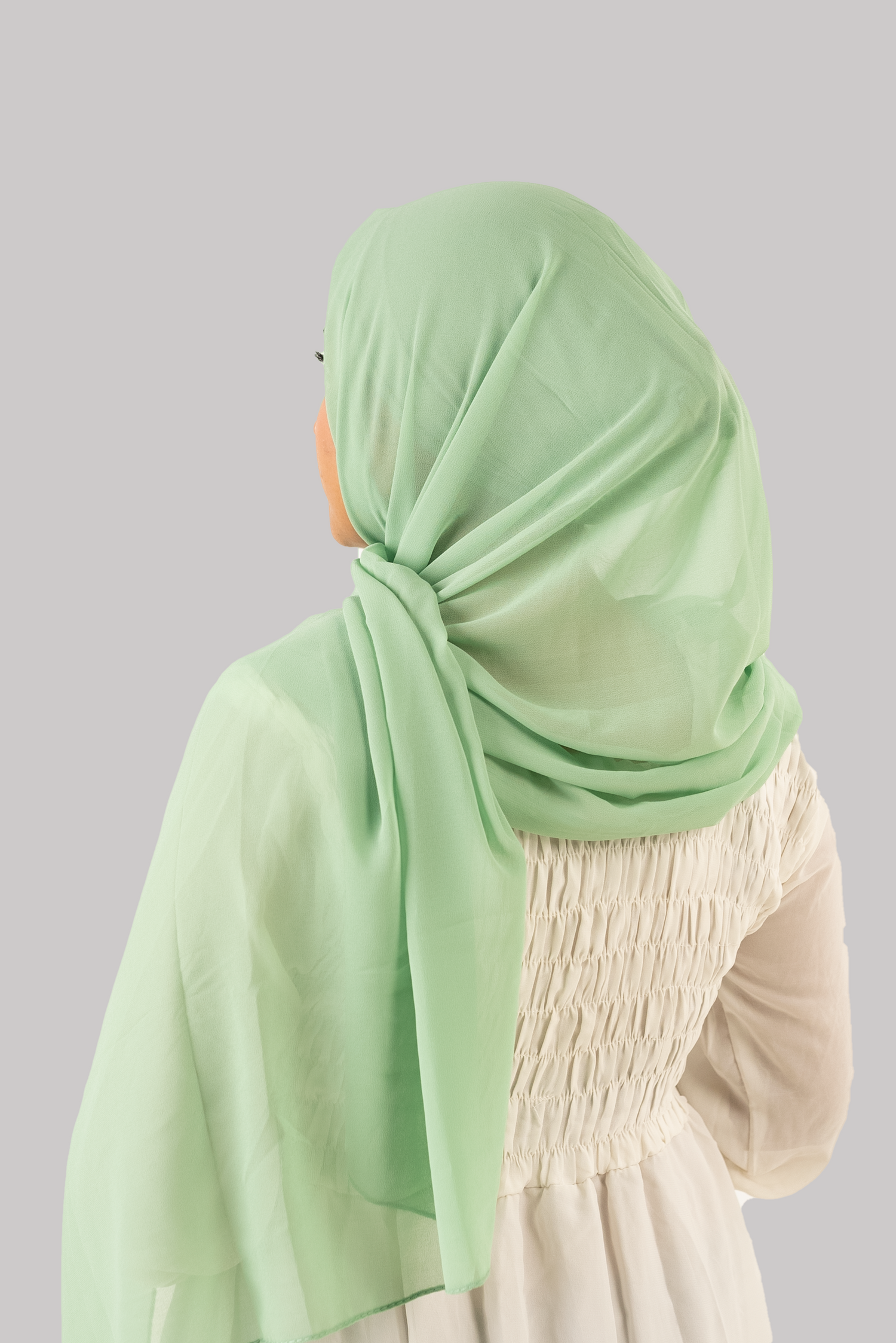 a women wearing instant hijab with cap in pistachio color georgette material back side