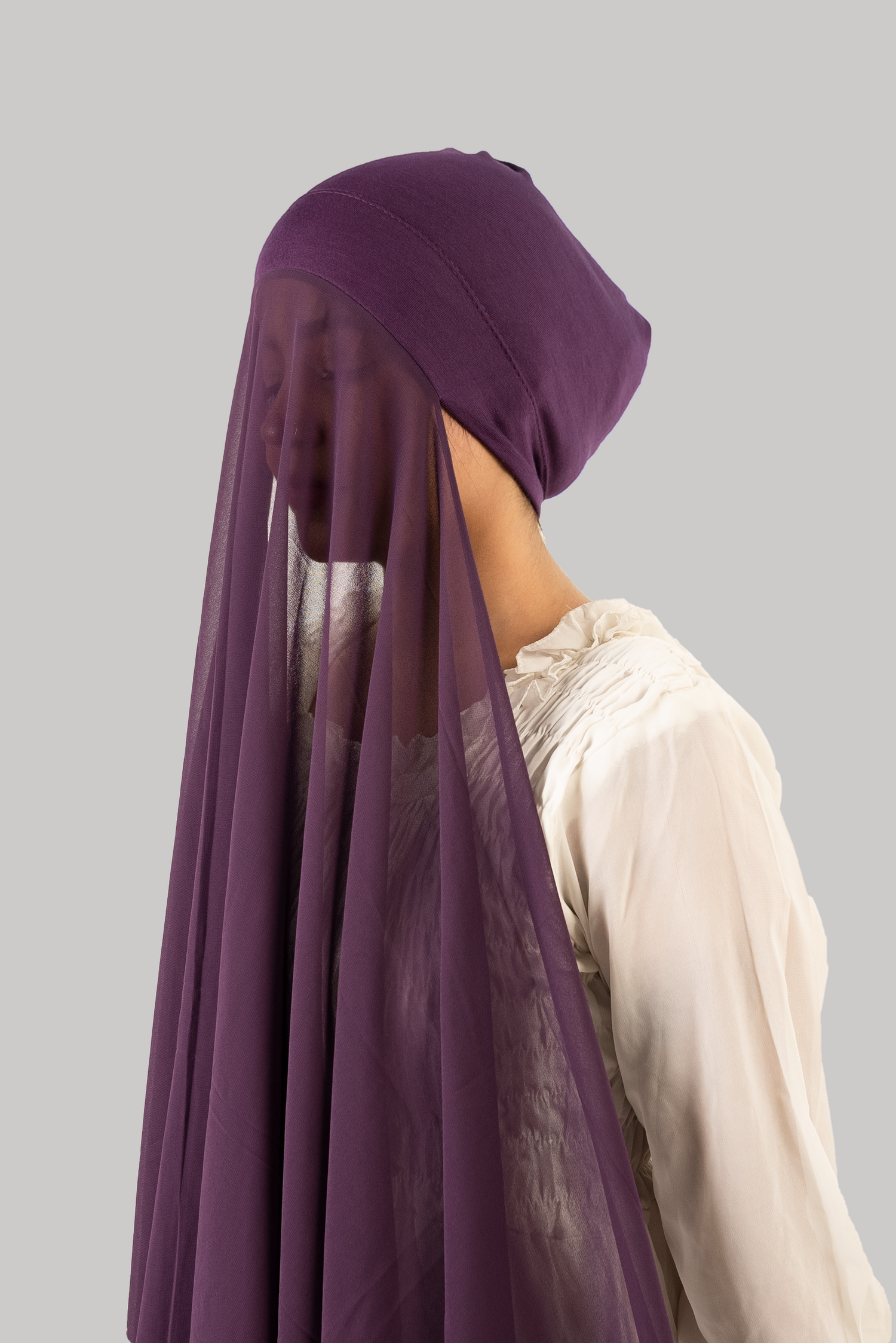 a women wearing instant hijab with cap in purple color georgette material side profile