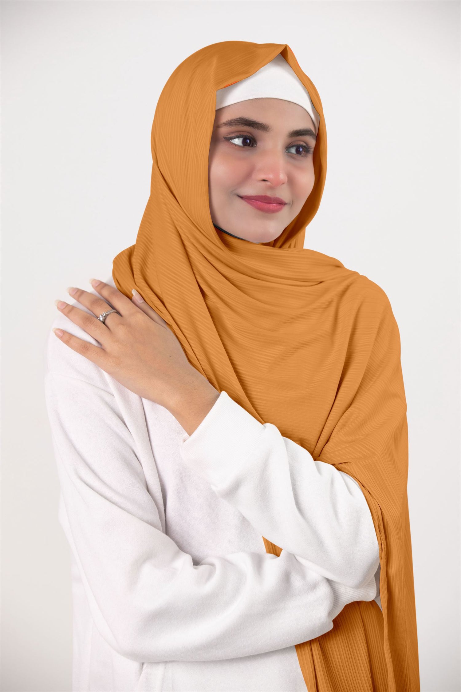 Ribbed Jersey Hijab in mustard. Fashion-forward hijabi draping it for an elegant appearance. 