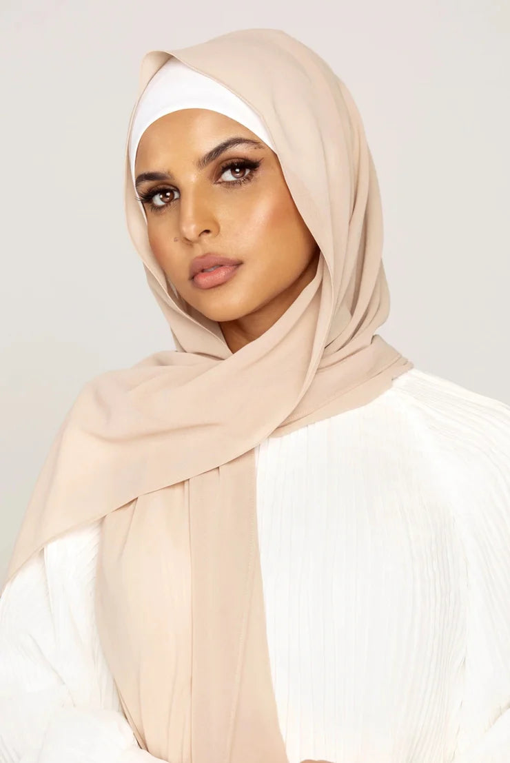 Georgette Hijab Online Pakistan, in oatmeal color . a woman wearing it with white top looking her straight