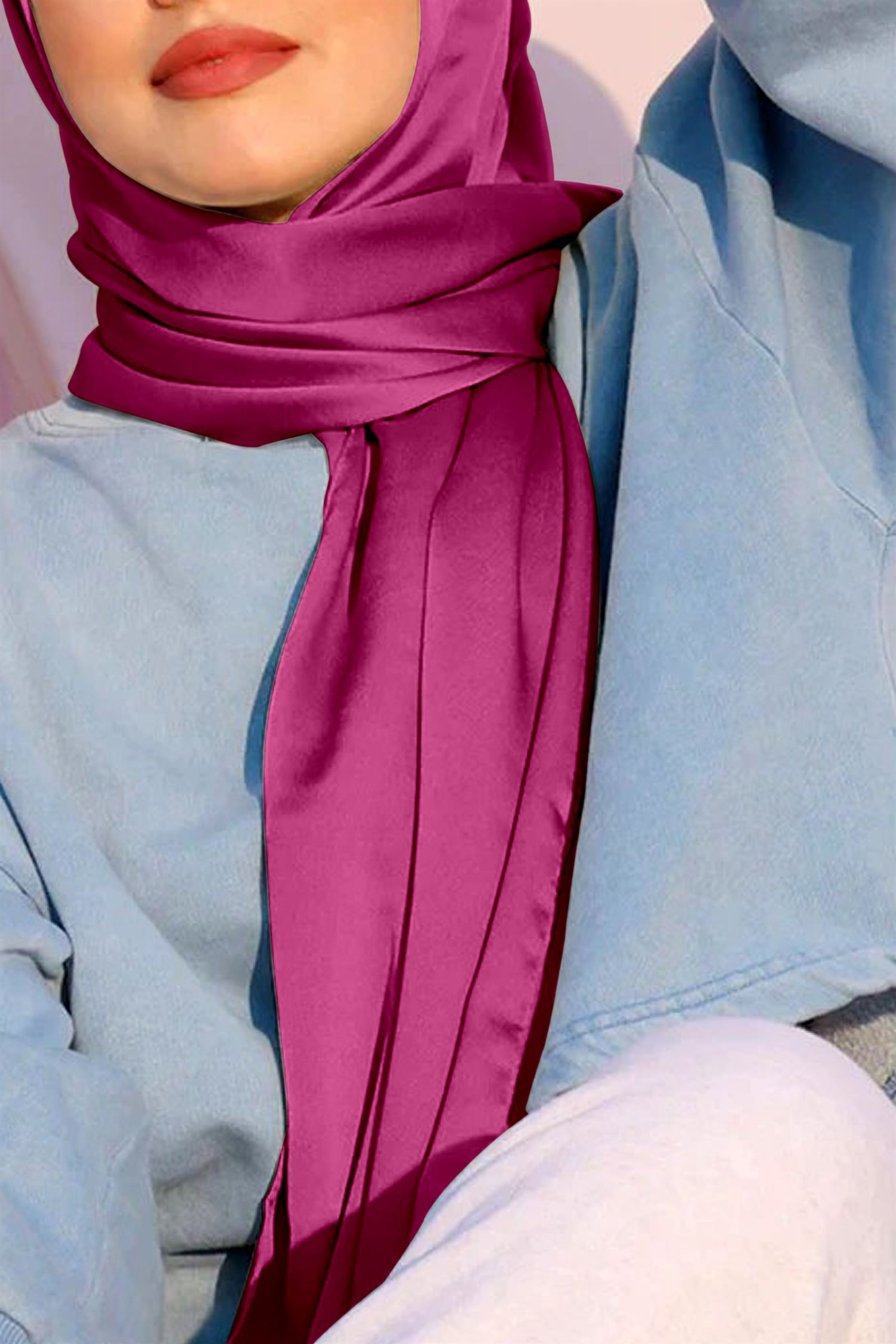 A woman wearing satin silk hijab. shocking pink color.