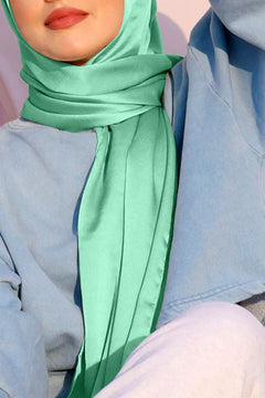 Satin silk hijab in ever green. Stylish woman wearing hijab.