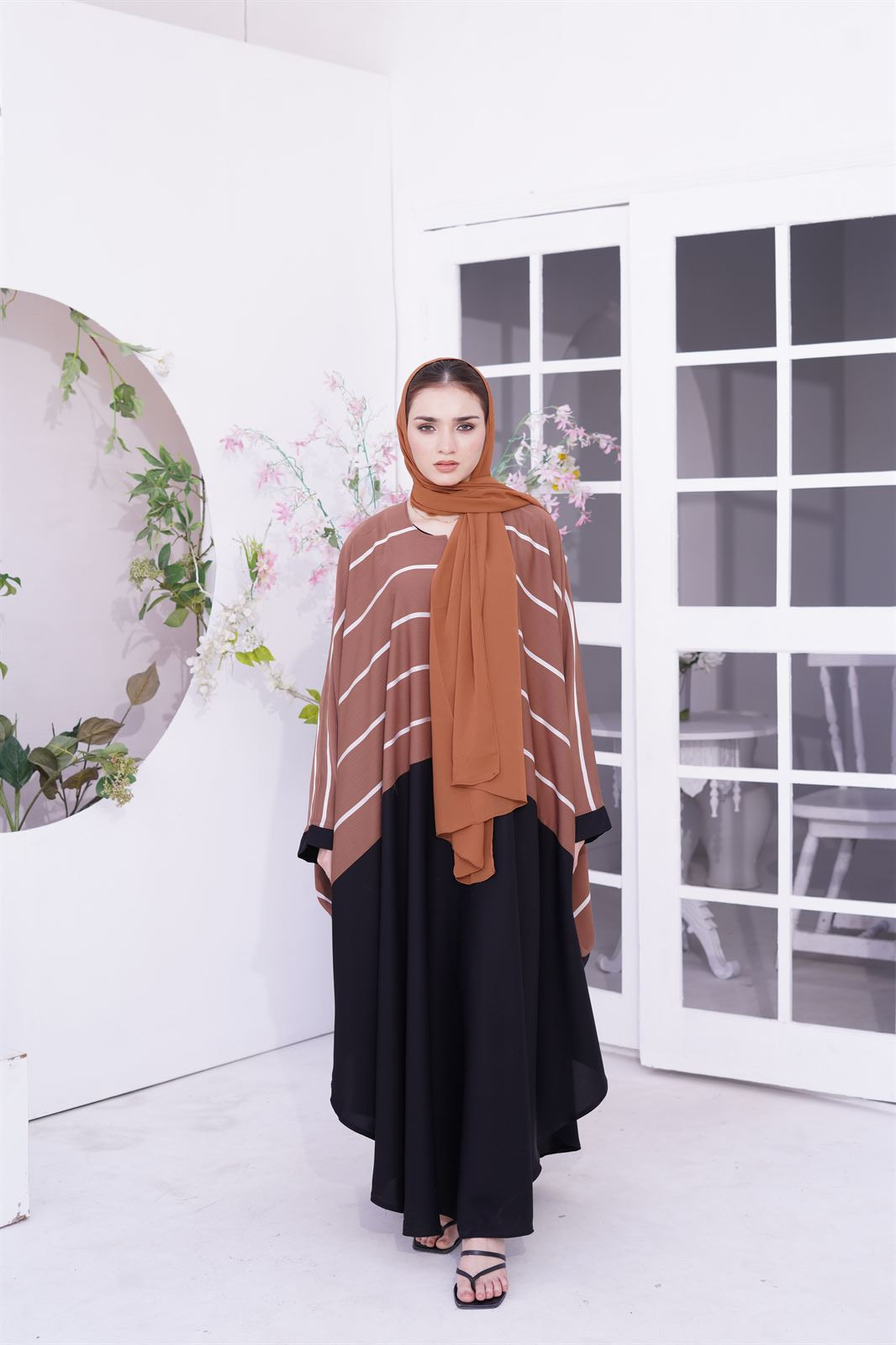 Front look of Girl standing and wearing Zoom Line Jilbab abaya design in light brown.