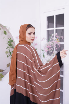 Girl wearing Zoom line Jilbab abaya design in light brown. looking back.