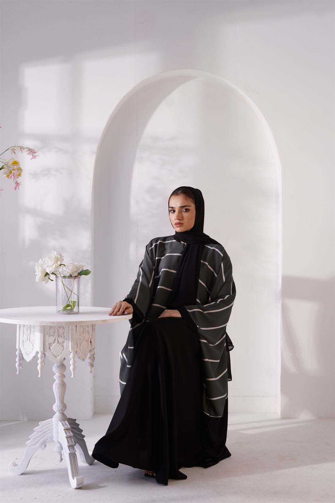 Girl wearing Zoom line Abaya Jilbaba Online in foxtons sitting on chair.