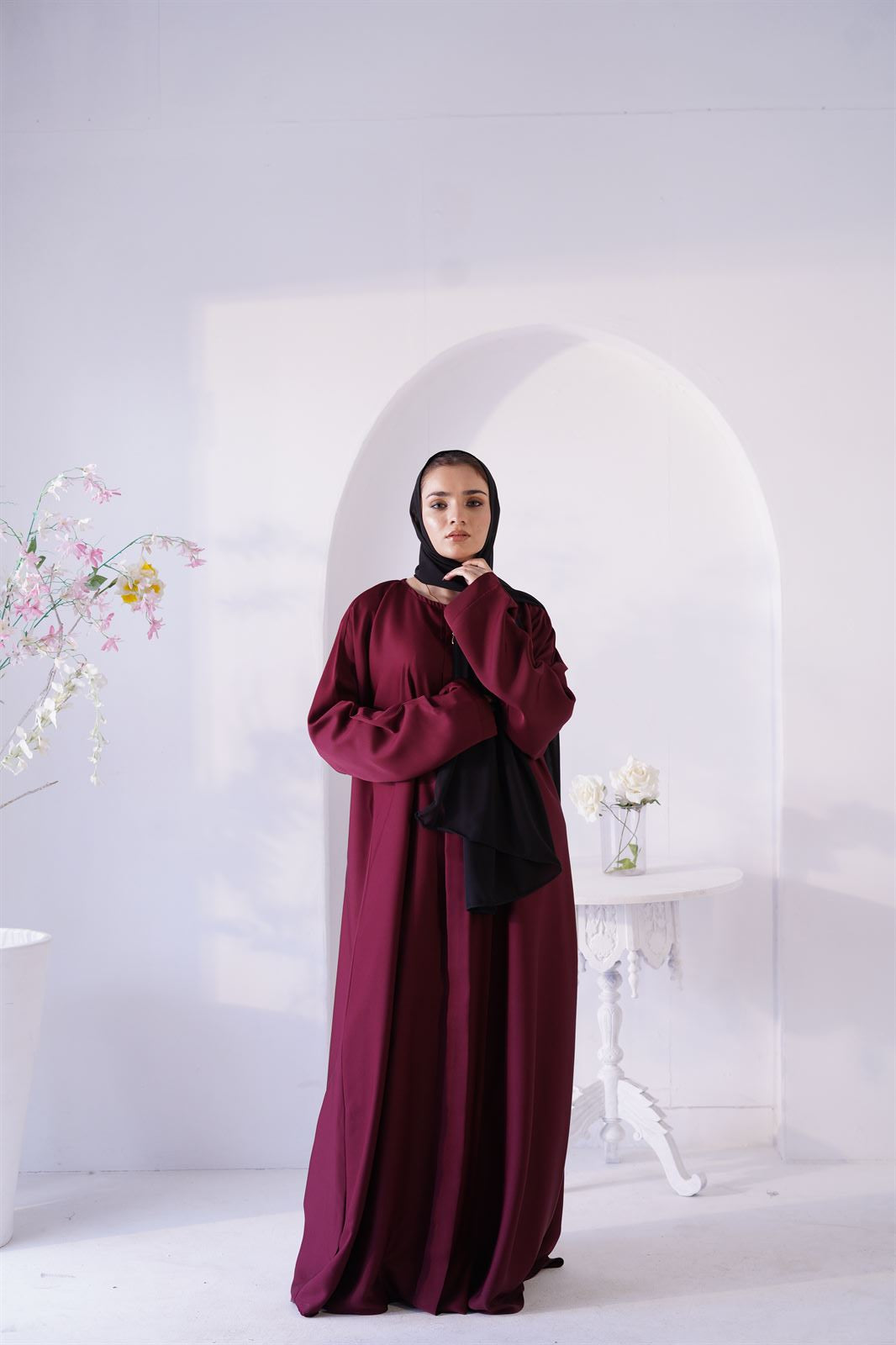 Luxury Abaya Online. Woman Wearing Amirah Abaya In maroon color. Front view.