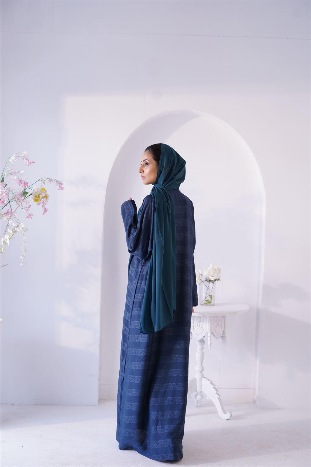 Girl wearing Zoom emboss Gown Abaya in Peacock shade. Back view.