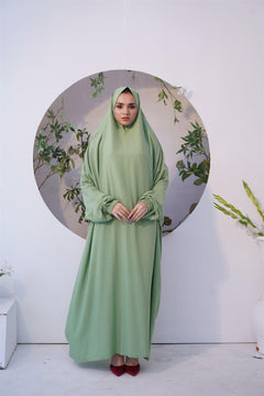 A lady wearing salah chadar in green color