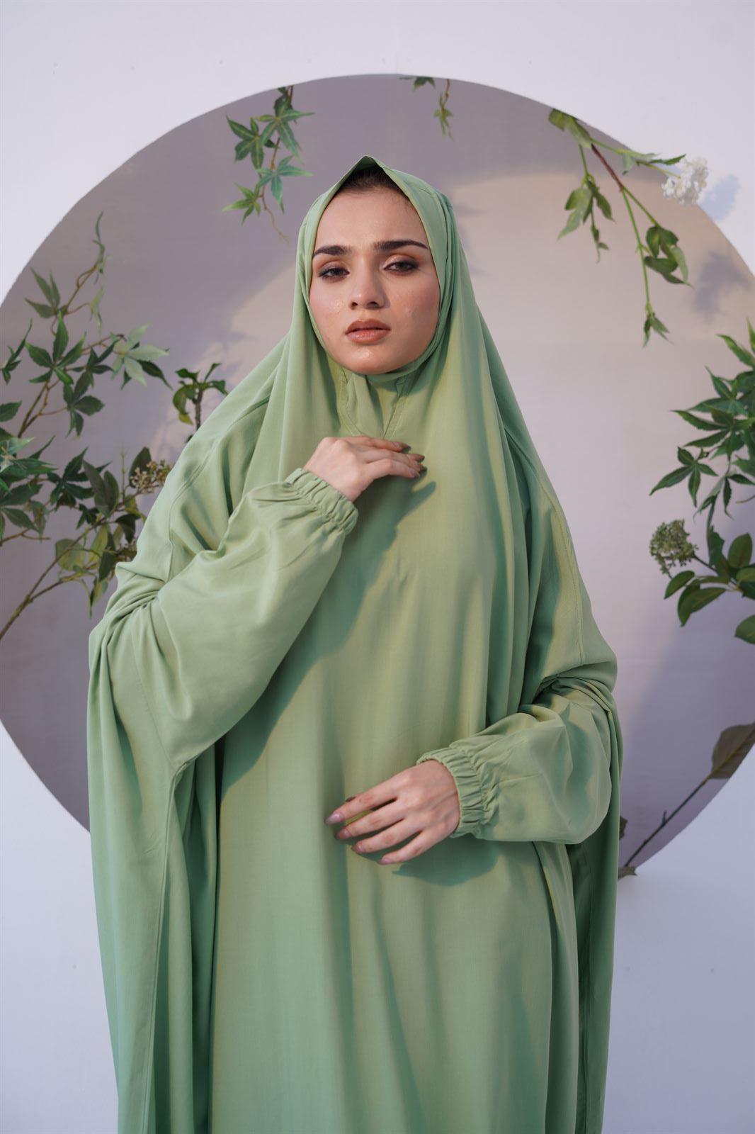 A girl wearing namaz chadar with sleeves in green color 