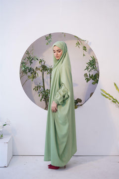 A women wearing namaz chadar in pakistan in green color 