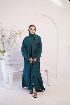 Girl wearing Nida Fabric Gown Style Abaya in Pine Green. Front view.