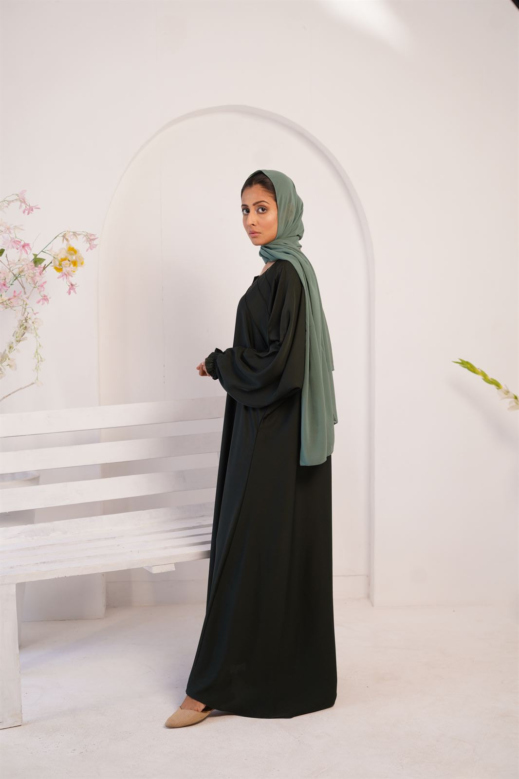 Buy Kaftan maxi abaya online in bottle green. side view of Girl wearing maxi abaya.