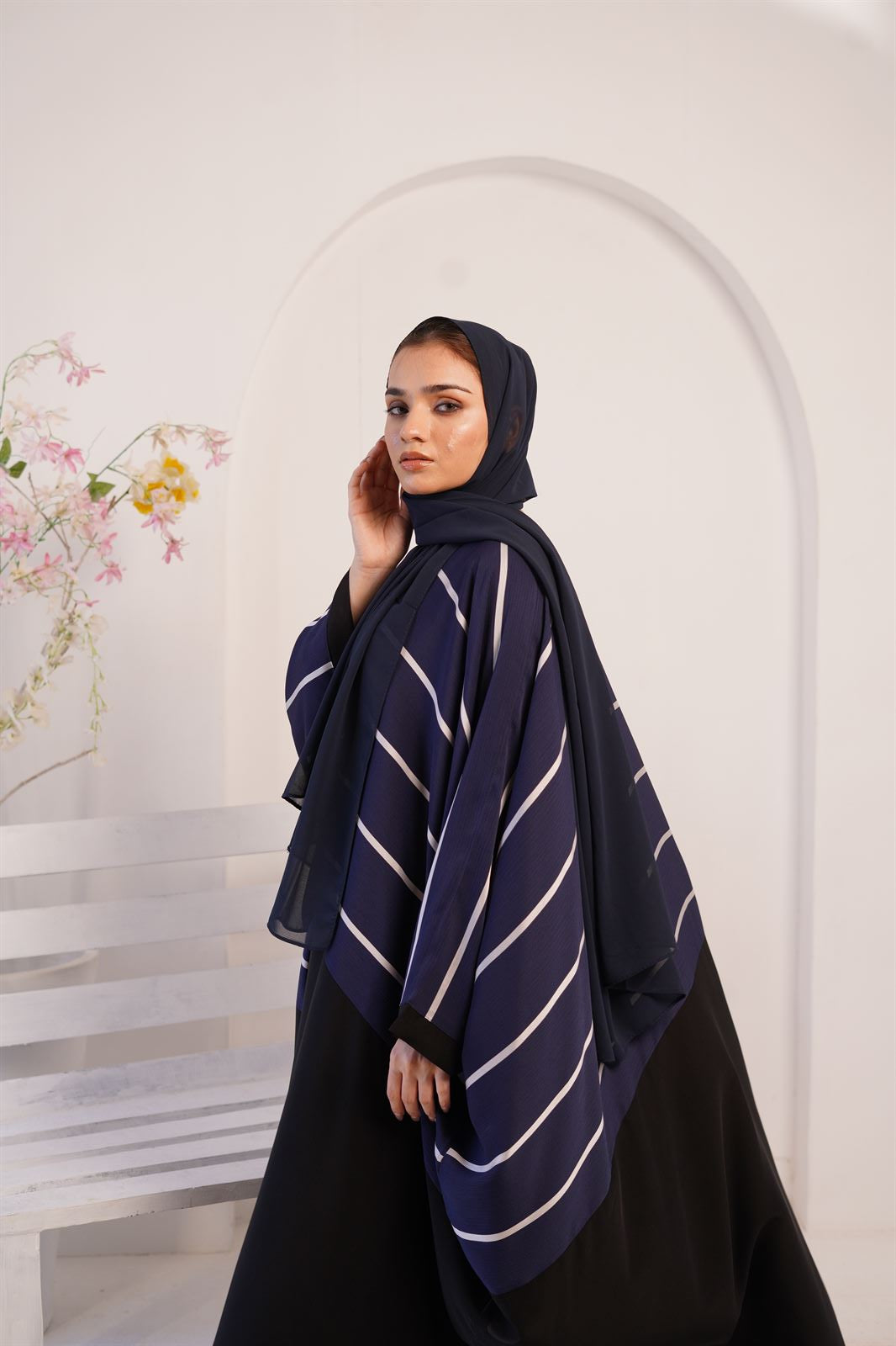 Side view of girl wearing zoom line ladies jlbab abaya in navy blue. 