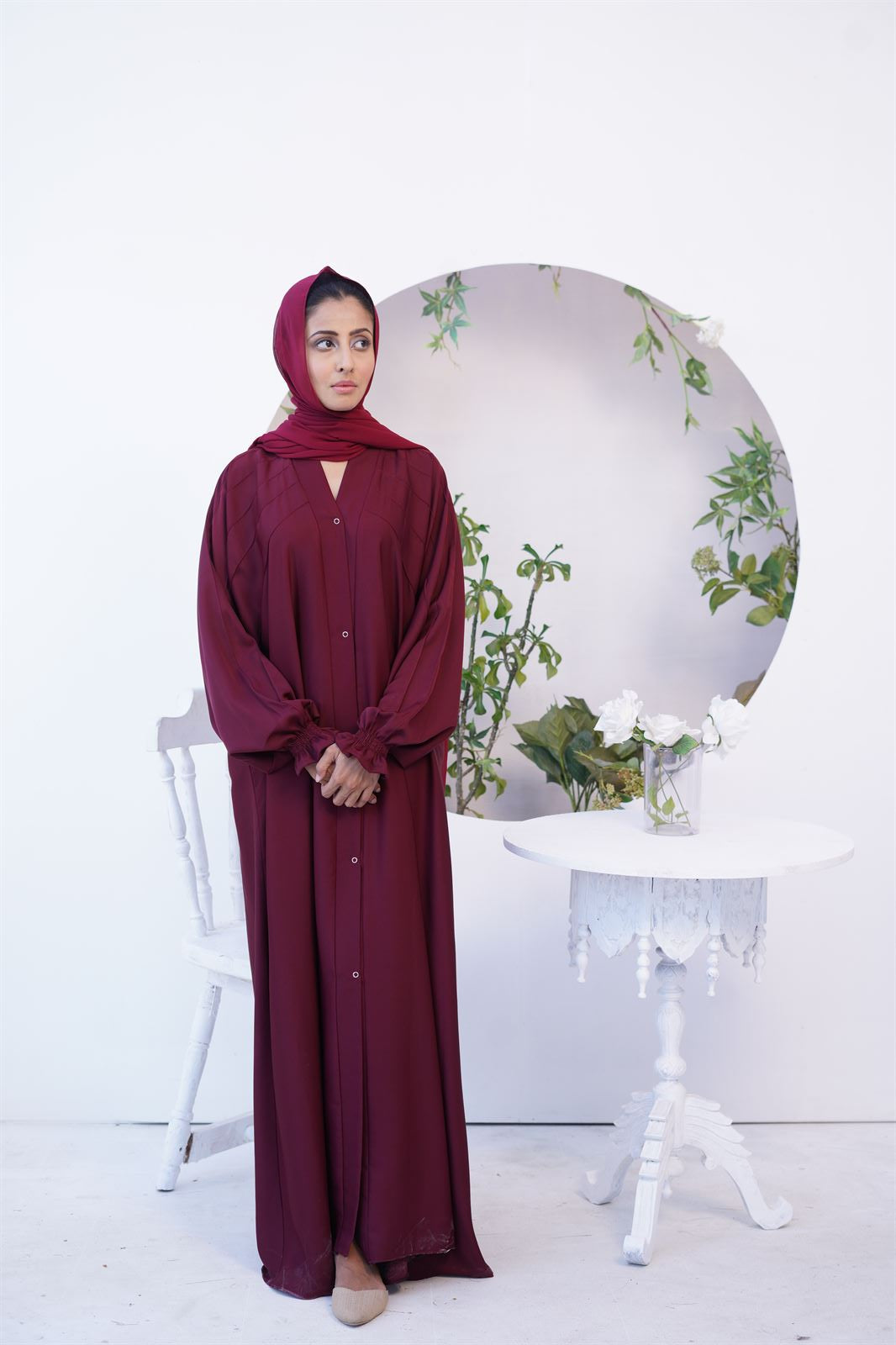 Girl Wearing Paintex Gown Style Kaftan abaya Online in maroon. Front view.