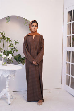 Girl wearing light brown Zoom Emboss Abaya Gown Style. front view.