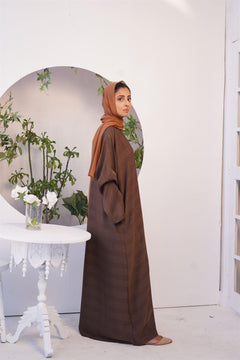 Girl wearing light brown Zoom emboss abaya Gown Style. side view.