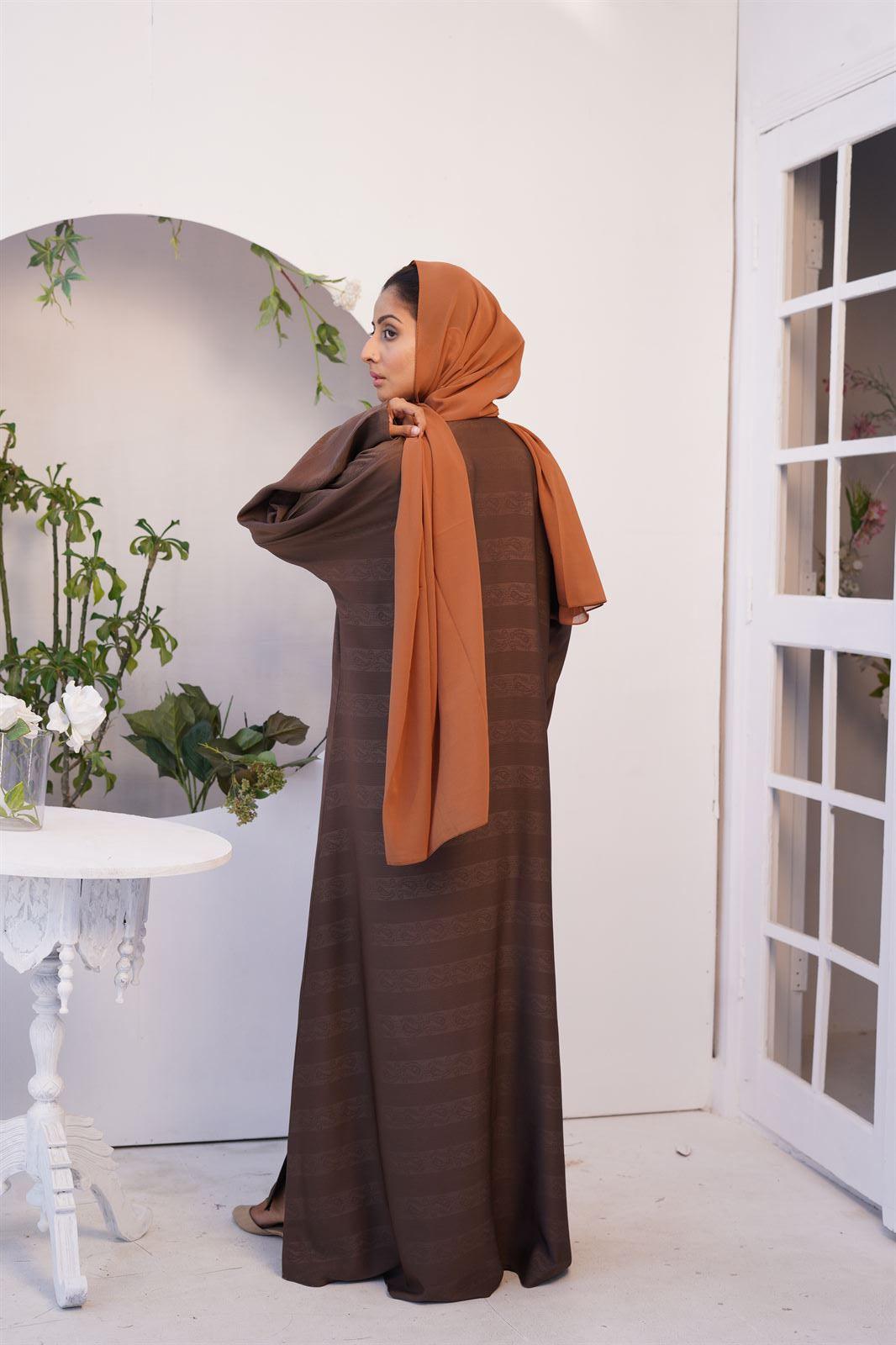 Girl wearing light brown Zoom Emboss Abaya Gown Style. back view.