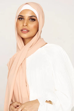 Georgette Hijab Online Pakistan, in nude color. A woman wearing it with white top looking her straight.