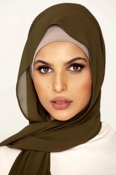 Georgette Hijab Online Pakistan, in olive green color . a women wearing it with white top looking her striahgt.