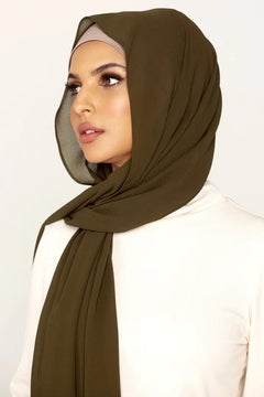 Georgette Hijab Online Pakistan, in olive green color . a women wearing it with white top looking her right