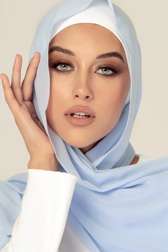 Georgette Hijab Online Pakistan, in baby blue color . a women wearing it with white top looking her straight.