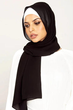 Black Georgette Hijab Online Pakistan. Woman wearing an over-white top looking to her right bottom.