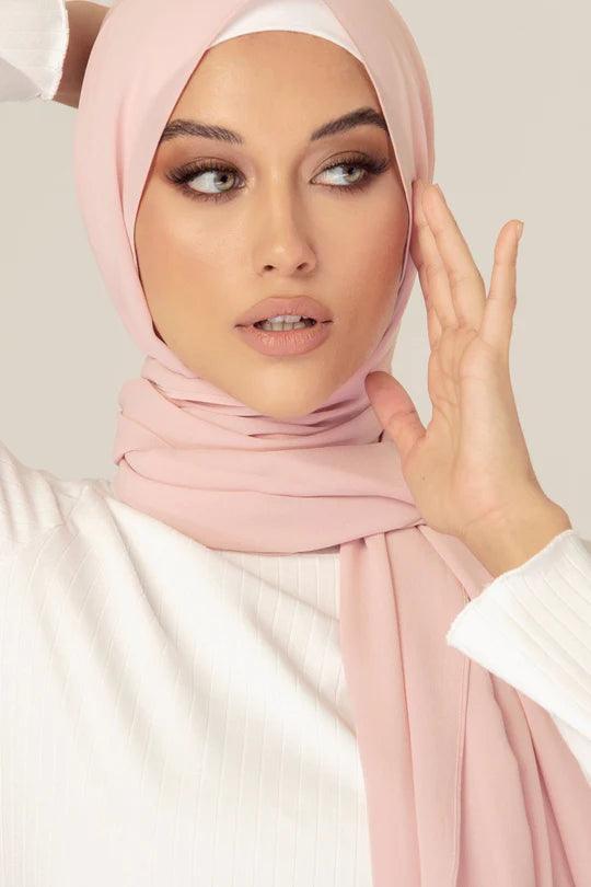 Georgette Hijab Online Pakistan, in nude rose color . a women wearing it with white top looking her left