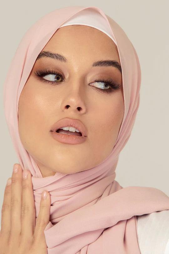 Georgette Hijab Online Pakistan, in nude rose color . a women wearing it with white top looking her left.