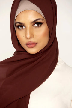 Georgette Hijab Online Pakistan, in nutella color . a women wearing it with white top looking her straight.