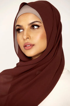 Georgette Hijab Online Pakistan, in Nutella color . a women wearing it with white top looking her right.