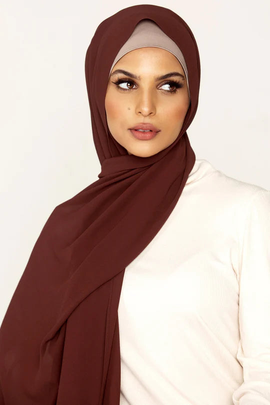 Georgette Hijab Online Pakistan, in nutella color . a women wearing it with white top looking her left.