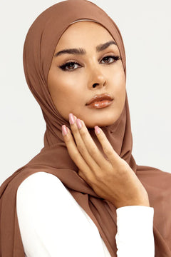 Georgette Hijab Online Pakistan, in dark mocha color . a women wearing it with white top looking her straight.