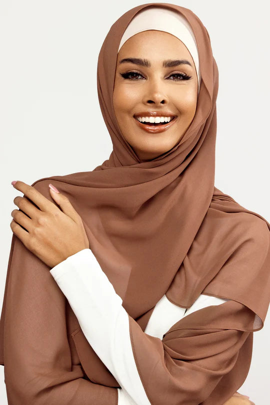 Georgette Hijab Online Pakistan, in dark mocha color . a woman wearing it with white top looking her straight.