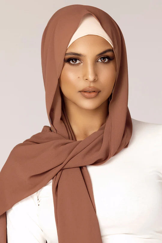 Georgette Hijab Online Pakistan, in mocha color . a women wearing it with white top looking her straight.