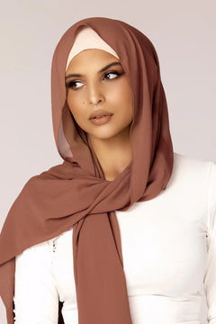 Georgette Hijab Online Pakistan, in mocha color . a women wearing it with white top looking her right